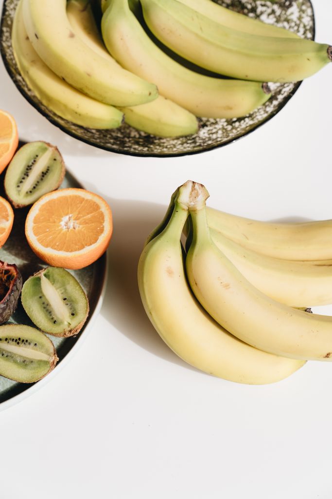 Close-up view of fresh tropical fruits including bananas, kiwi, and orange slices.